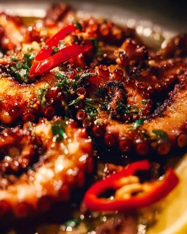 Crispy marinated baby octopus served on a plate with garnish.