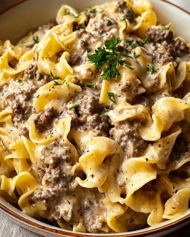 Delicious Ground Beef Stroganoff served with pasta and garnished with parsley.