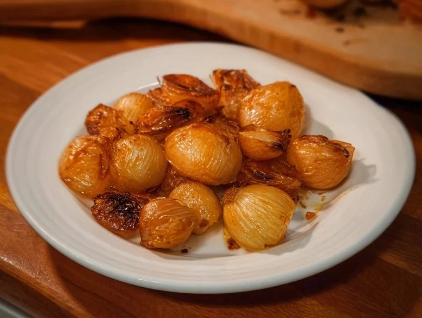 Air fryer pearl onions cooking in an air fryer basket.